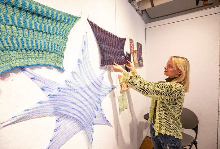 Student installing fabrics on a wall for an exhibition. Links to Donor-Advised Fund Student installing fabrics on a wall for an exhibition. Links to Donor-Advised Fund