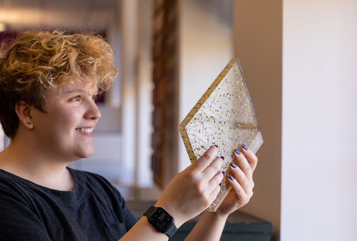 Student holding a piece of glass. Links to Gifts of Appreciated Securities Student holding a piece of glass. Links to Gifts of Appreciated Securities